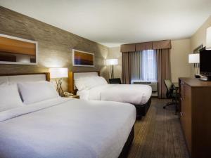 a hotel room with two beds and a television at Holiday Inn Saratoga Springs, an IHG Hotel in Saratoga Springs