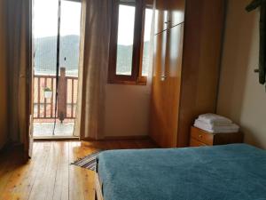 a bedroom with a bed and a large window at Agios Achillios in Agios Achillios