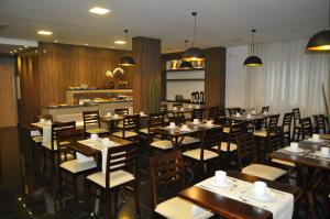 a dining room with wooden tables and chairs at Hospedare Hotel in Marechal Cândido Rondon