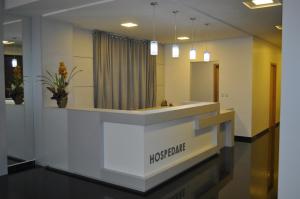 a reception desk in a hospital lobby with a mirror at Hospedare Hotel in Marechal Cândido Rondon