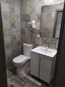 a bathroom with a toilet and a sink at Fermont Playa Foz in Foz