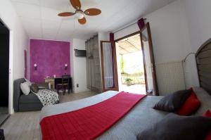 1 dormitorio con 1 cama grande con manta roja en Hôtel Les Orangers, en Hyères