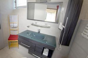 a bathroom with a sink and a mirror at Hôtel Les Orangers in Hyères