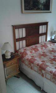 1 dormitorio con 1 cama y 1 mesa con lámpara en Blue House en Buenos Aires