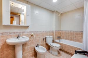 La salle de bains est pourvue de toilettes, d'un lavabo et d'une baignoire. dans l'établissement Soho Riverside Suite Málaga, à Malaga