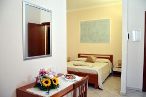 a hotel room with a bed and a mirror at Le Grotte in Castro di Lecce