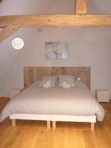 ein Schlafzimmer mit einem Bett mit Kissen darauf in der Unterkunft Chambres d'Hôtes Les Potiers in Sens-Beaujeu