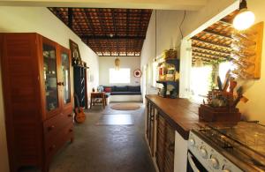 a kitchen with a counter and a living room at Casa Lolô Atins in Atins