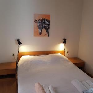 a bedroom with a bed with a picture of a zebra on the wall at Holiday home Marija in Karlobag