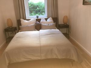 een groot wit bed in een kamer met een raam bij Ferienwohnung Atze in Berlijn