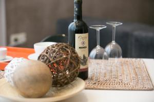 een fles wijn naast een tafel met een bal en wijnglazen bij Gala House in Kavala