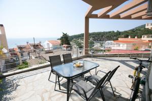een patio met een tafel en stoelen op een balkon bij Gala House in Kavala