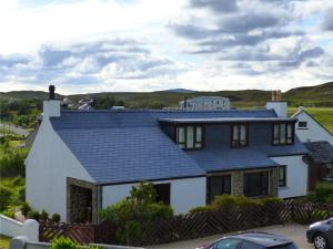 a white house with a blue roof at Glenhouse in Leurbost