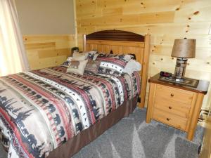 een slaapkamer met een bed en een tafel met een lamp bij Loon Lodge in Phelps
