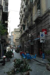 ナポリにあるア ドゥエ パッシ ダ ダンテの椅子・テーブル・建物のある街道