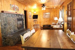 a dining room with a wooden table and a fireplace at Copper King Lodge in Red River
