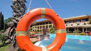 an orange lifesaver hanging from the side of a swimming pool at Villa Madrina Lovely and Dynamic Hotel in Garda