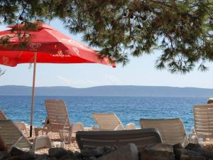 a group of chairs and an umbrella on a beach at Ferienhaus Ivanka in Trogir