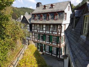 un vieux bâtiment avec des volets verts dans une ville dans l'établissement Haus Stehlings, à Monschau