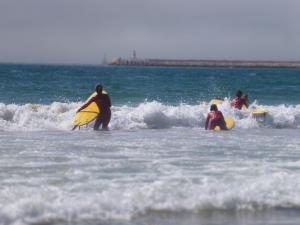 a group of people in the ocean with surfboards at Chez Odete in Figueira da Foz