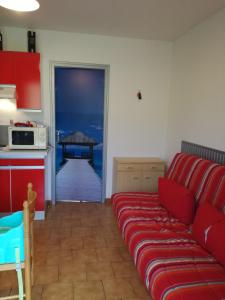 エスパラン・ド・ヴェルドンにあるRésidence les Cadesのリビングルーム(赤いソファ付)、キッチン