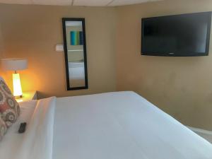 a bedroom with a large white bed with a flat screen tv at Haven Hotel - Fort Lauderdale Hotel in Fort Lauderdale