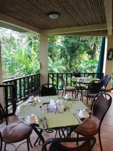 d'une salle à manger avec des tables et des chaises sur un balcon. dans l'établissement Heliconia Island, à Sarapiquí