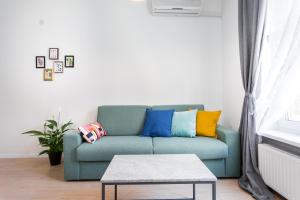 a living room with a blue couch with colorful pillows at Go2Zagreb Chick Apartment in Zagreb