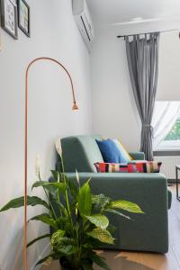 a living room with a green couch and a plant at Go2Zagreb Chick Apartment in Zagreb