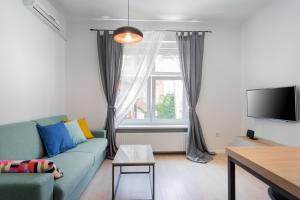 a living room with a blue couch and a window at Go2Zagreb Chick Apartment in Zagreb
