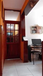 Zimmer mit einer Tür und einem Schreibtisch mit einem Laptop in der Unterkunft Hotel Residencial Casal in La Paz