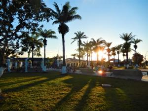 un parque con palmeras y puesta de sol en Hospedaje Neydita en Iquitos