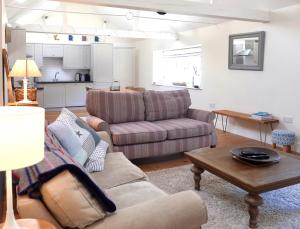 uma sala de estar com um sofá e uma mesa em Bakers Court em East Rudham