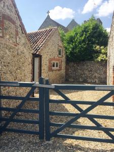 an open gate in front of a stone building at Bakers Court in East Rudham