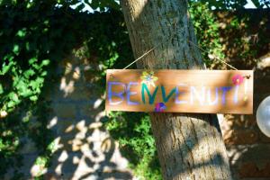 a sign on a tree with the word beware at Dependance Miluna in Nettuno