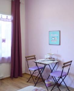 uma sala de jantar com uma mesa e duas cadeiras em Dependance Miluna em Nettuno