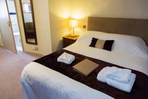 a hotel room with a bed with towels and a book at The Talbot Hotel in Ledbury