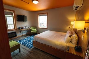 1 dormitorio con cama, escritorio y silla en Adventure Hotel, en Nelson