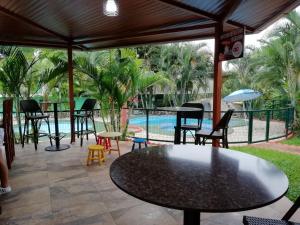 a patio with tables and chairs and a pool at Villa Guarias in Puntarenas