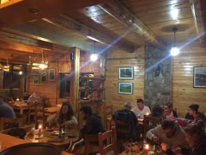 a group of people sitting at tables in a restaurant at B&B Izvor in Žabljak