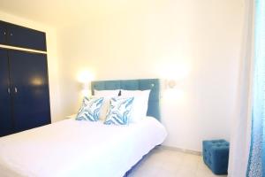 a bedroom with a bed with blue and white pillows at Quinta Nova Apartment by Trip2Portugal in Alvor