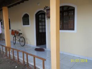 uma bicicleta estacionada ao lado de uma casa em cantinho do sossego oficial em Caraguatatuba