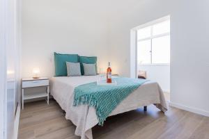 een slaapkamer met een bed en een tafel met een kaars erop bij Casa da Vila in Vila do Bispo