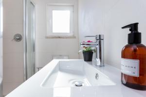 un dispenser di sapone, posto su un lavandino in bagno di Casa da Vila a Vila do Bispo Altre 12 foto