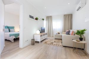un soggiorno bianco con un divano e una TV di Casa da Vila a Vila do Bispo