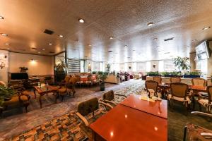 a restaurant with tables and chairs in a room at Kyungha Spa Hotel in Daejeon