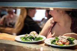 a woman sitting at a table with two plates of food at Arrowhead Mountain Lodge in Cimarron