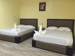 2 Betten nebeneinander in einem Zimmer in der Unterkunft Meaco Royal Hotel - Plaridel in Plaridel