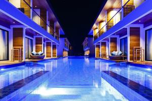 an indoor swimming pool in a building with lights at AKIRA Lipe Resort in Ko Lipe
