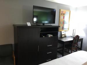 a black dresser with a television on top of it at Inn at Portland in Portland